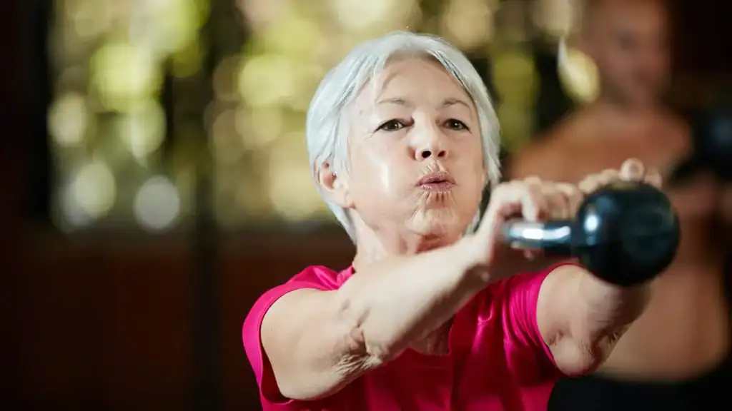 Older woman doing weight training Peterborough to help her strength and longevity 
