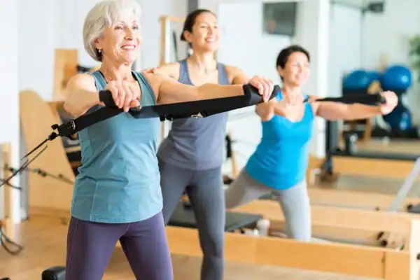 Toning Arms After 60: Empowering Womens Fitness Through Effective Weight Training 2 older woman doing weight training Peterborough and resistance in the gym to tone upper arms