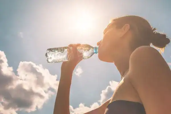 Hydration: The Secret Ingredient for a Toned Stomach and Enhanced Fitness 3 Image of woman drinking water to hydrate Peterborough after run.