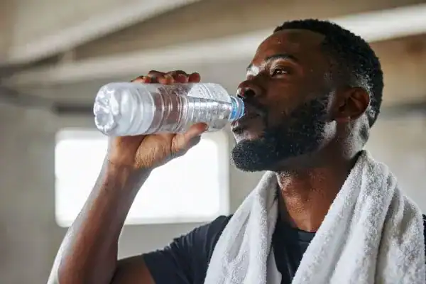 Hydration: The Secret Ingredient for a Toned Stomach and Enhanced Fitness 1 Image of man drinking water to improve hydration Peterborough after work out.